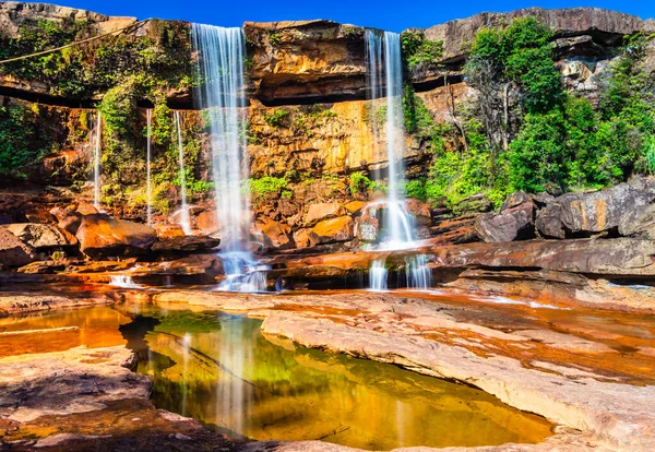 Şelale dağın tepesinden düşerken yansıma ve mavi gökyüzü sabah eşsiz bir açıyla