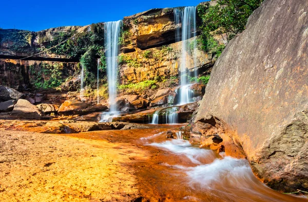 Şelale dağın tepesinden düşüyor. Mavi gökyüzü sabah eşsiz bir açıyla.