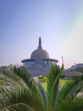 Buddha stupa, 15 Nisan 2022 'de Buda Parkı patna bihar Hindistan' da alçak açılı görüntüden parlak gökyüzü yaprakları arasında çekilmiştir..