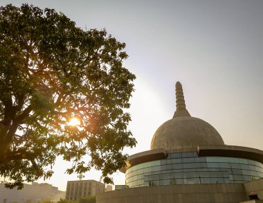 Buddha stupa, 15 Nisan 2022 'de Buda Parkı patna bihar Hindistan' da alçak açılı görüntüden parlak gökyüzü yaprakları arasında çekilmiştir..