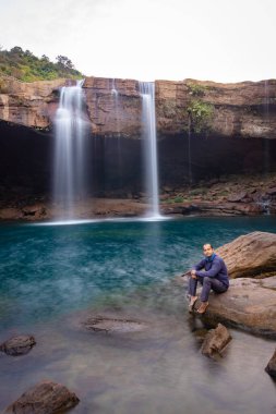 Şelale dereleri olan genç adam sabahleyin dağdan düşüyor uzun pozlu fotoğraf Krangsuri Şelalesi meghalaya Hindistan 'da çekiliyor..