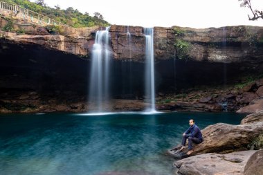 Şelale dereleri olan genç adam sabahleyin dağdan düşüyor uzun pozlu fotoğraf Krangsuri Şelalesi meghalaya Hindistan 'da çekiliyor..