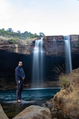 Şelale dereleri olan genç adam sabahleyin dağdan düşüyor uzun pozlu fotoğraf Krangsuri Şelalesi meghalaya Hindistan 'da çekiliyor..