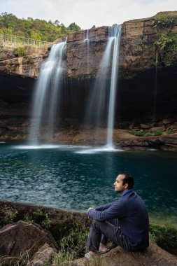 Şelale dereleri olan genç adam sabahleyin dağdan düşüyor uzun pozlu fotoğraf Krangsuri Şelalesi meghalaya Hindistan 'da çekiliyor..
