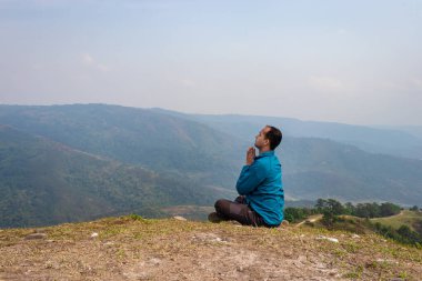 Tepenin zirvesinde sisli dağ öfkesiyle meditasyon yapan bir adam düz açılı görüntüden Hindistan 'da çekilmiştir..