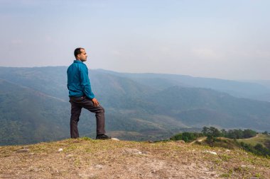 Tepenin tepesinde tek başına duran sisli dağ öfkesi arka planında düz açı görüntüsü Nongjrong meghalaya Hindistan 'da çekilmiştir..