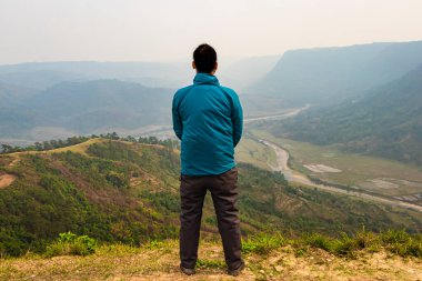 Tepenin tepesinde tek başına duran sisli dağ öfkesi arka planında düz açı görüntüsü Nongjrong meghalaya Hindistan 'da çekilmiştir..