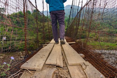 Antika demir asma köprüsünde yürüyen adamın görüntüsü Hindistan 'ın Nongjrong meghalaya şehrinde çekildi..