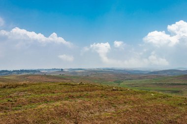 Düz açılı, parlak mavi gökyüzü ile dağlık tarım tarlaları