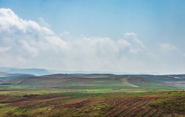 Düz açılı, parlak mavi gökyüzü ile dağlık tarım tarlaları