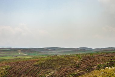 Düz açılı, parlak mavi gökyüzü ile dağlık tarım tarlaları