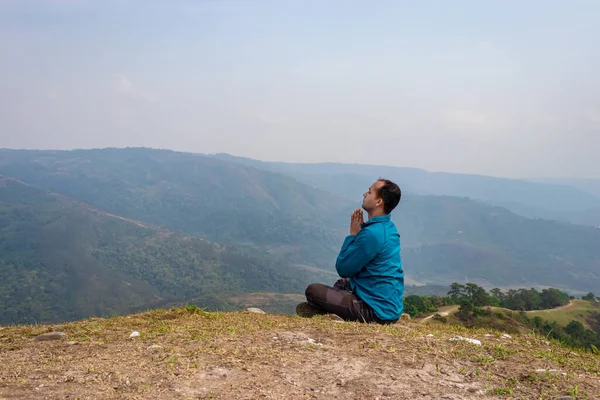man meditating at hill top with misty mountain rage background from flat angle image is taken at nongjrong meghalaya india.