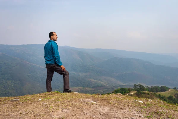 Tepenin tepesinde tek başına duran sisli dağ öfkesi arka planında düz açı görüntüsü Nongjrong meghalaya Hindistan 'da çekilmiştir..