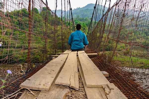 Antika demir süspansiyon köprüsünde meditasyon yapan adam, düşük açılı görüntü Nongjrong meghalaya Hindistan 'da çekildi..