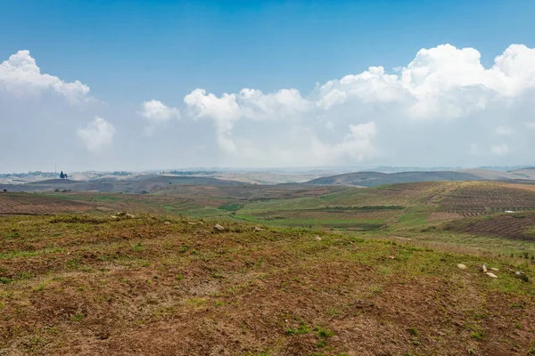 Düz açılı, parlak mavi gökyüzü ile dağlık tarım tarlaları