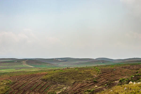 Düz açılı, parlak mavi gökyüzü ile dağlık tarım tarlaları