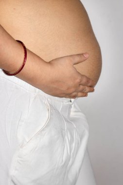 Genç hamile kadınlar karnının yuvarlak kısmını farklı açılardan elleriyle gösteriyor.