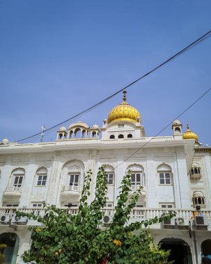 Gurudwara binası, altın kubbe ve düz gökyüzü ile farklı açılardan 22 Mayıs 2022 'de Gurudwara bangla sahib delhi Hindistan' da çekilmiştir..