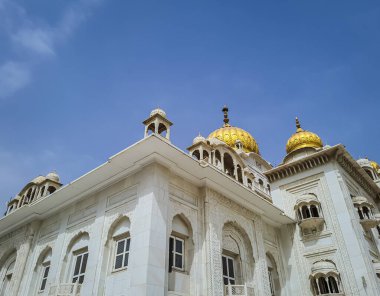 Gurudwara binası, altın kubbe ve düz gökyüzü ile farklı açılardan 22 Mayıs 2022 'de Gurudwara bangla sahib delhi Hindistan' da çekilmiştir..