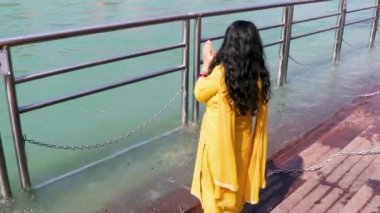 Ganga nehri kıyısındaki kutsal Ganj nehrinin düz açılı görüntülerini araştıran izole genç kız Ganga nehri kıyısı Haridwar uttrakhand Hindistan 'da çekildi..