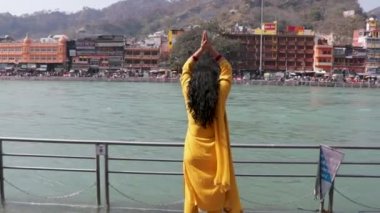 Ganga nehri kıyısındaki kutsal Ganj nehrinin düz açılı görüntülerini araştıran izole genç kız Ganga nehri kıyısı Haridwar uttrakhand Hindistan 'da çekildi..