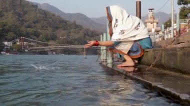 Farklı açılardan Ganga Nehri kıyısında dua eden genç Hintli kız Ganga Nehri kıyısında Rishikesh uttrakhand Hindistan 'da çekildi..