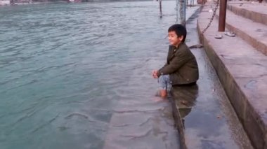 Kutsal Ganj Nehri kıyısında izole edilmiş genç bir çocuk düz açılı görüntüden Ganga Nehri kıyısındaki Rishikesh uttrakhand Hindistan 'da çekildi..