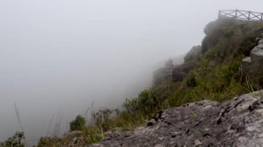 Düz açıyla dağın tepesine doğru hızla hareket eden beyaz sis