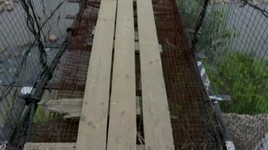 İzole edilmiş eski paslı demir süspansiyon köprüsü ile puslu düz gökyüzü arkaplanı sabah