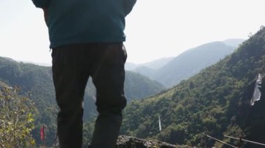 Mawryngkhang trek meghalaya Hindistan 'da, sabah yeşil ormanları ve sisli mavi gökyüzü ile izole genç adam düz açılı video çekilir..
