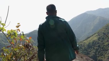 Mawryngkhang trek meghalaya Hindistan 'da, sabah yeşil ormanları ve sisli mavi gökyüzü ile izole genç adam düz açılı video çekilir..