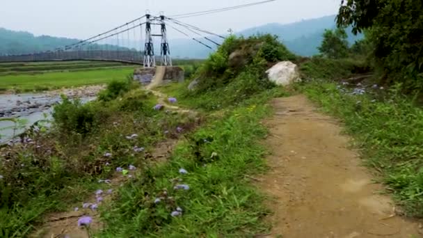 在Nongjrong Meghalaya India拍摄了早上拍摄的山蓝天空背景的河流上孤立的铁悬索桥 — 图库视频影像