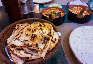 Yemekte farklı açılardan servis edilen lezzetli Hint yemekleri ile tandır ekmeği.