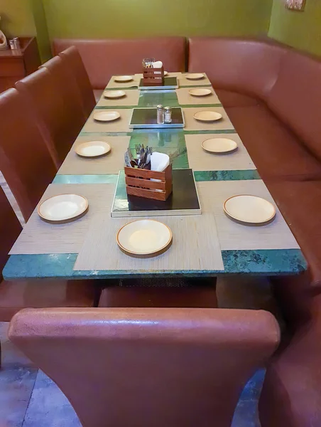 vacant chair with plats placed at restaurant table for dinner at night