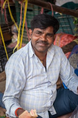 Sebze satıcısı yerel pazarda düz açılı görüntüden sebze satıyor. 17 Haziran 2022 'deki Delhi Sebze Pazarı Hindistan' da çekiliyor..