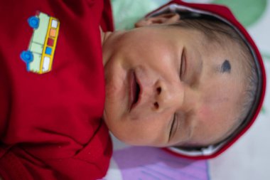 Sevimli yeni doğmuş bebek ağlaması, farklı açılardan kırmızı elbise