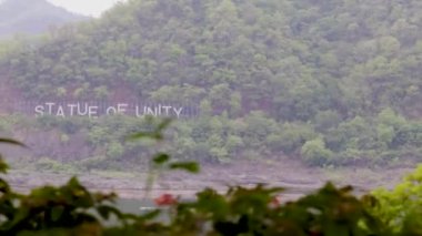 Birlik heykeli, 10 Temmuz 2022 'de vadodra gujrat Hindistan heykeli önünde düz açılı videodan nehir kenarındaki yeşil dağda yazıldı..