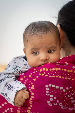 Sevimli bebek yüz ifadesi anne omuzunda düz açıyla dinleniyor.