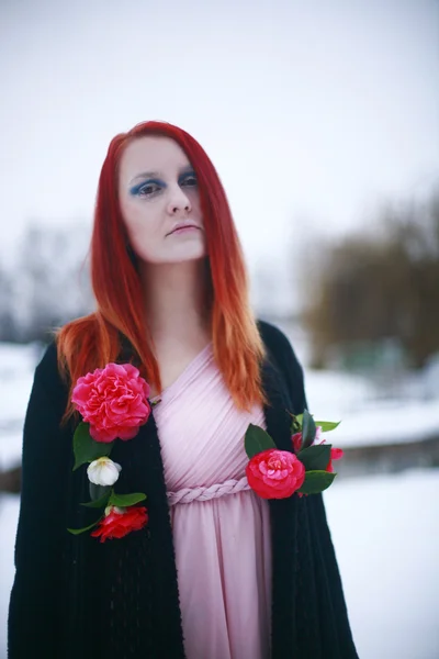 Red-haired girl in the winter garden with roses — Stock Photo, Image