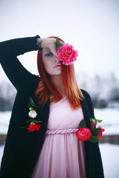 Fille aux cheveux roux dans le jardin d'hiver avec des roses — Photo