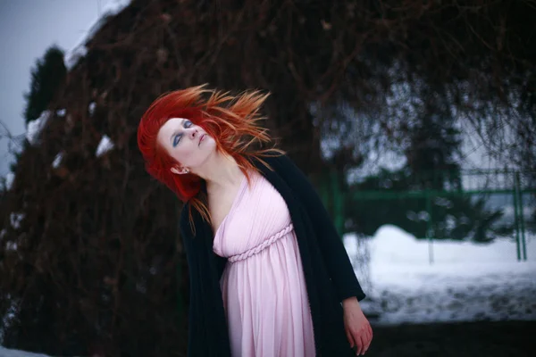 Beautiful red-haired girl in the winter garden — Stock Photo, Image