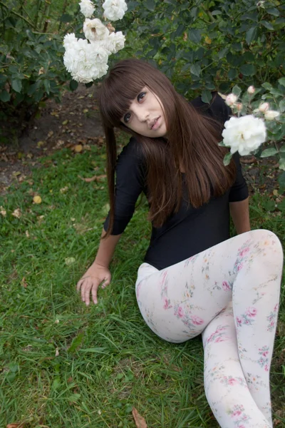 Girl and roses in botanical garden — Stock Photo, Image