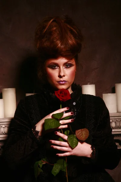 Kırmızı gül ile mumları yakın duran Gotik kız — Stok fotoğraf