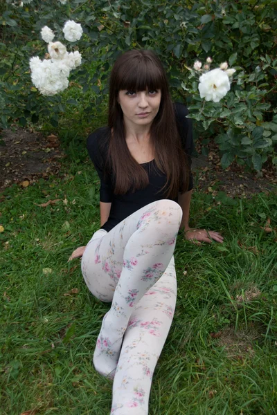 Chica y rosas en el jardín botánico — Foto de Stock