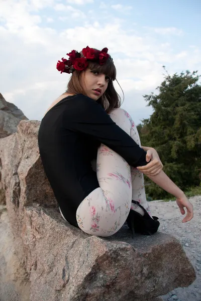 Menina em coroa de rosas no jardim botânico — Fotografia de Stock