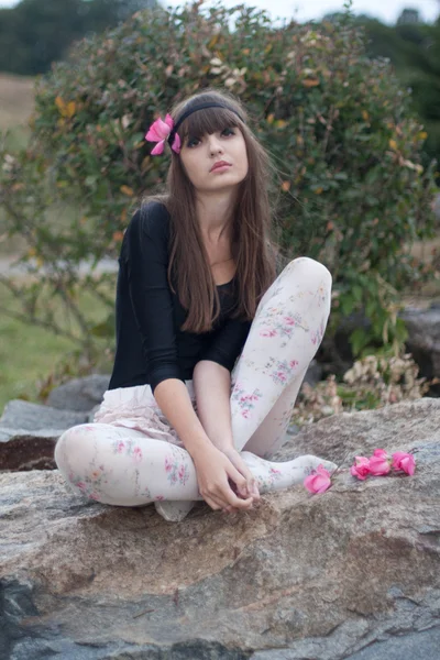Menina em coroa de rosas no jardim botânico — Fotografia de Stock