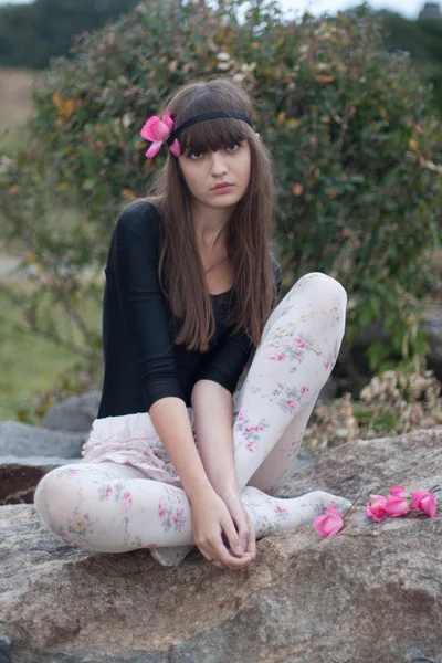 Menina em coroa de rosas no jardim botânico — Fotografia de Stock