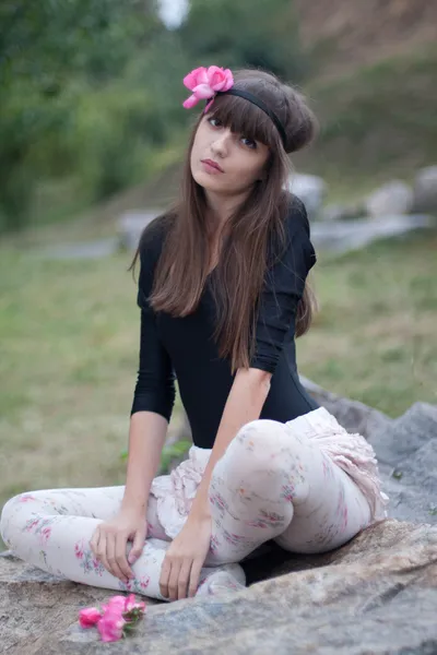 Menina em coroa de rosas no jardim botânico — Fotografia de Stock