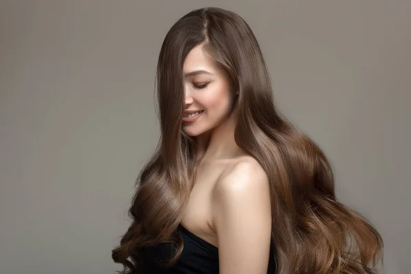 Uzun dalgalı saçlı güzel esmer bir kadının portresi. Kopyala