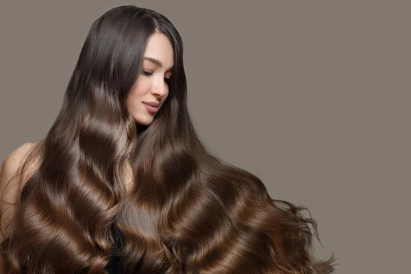 Uzun dalgalı saçlı güzel esmer bir kadının portresi. Kopyala